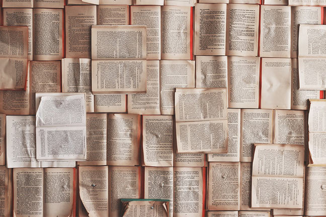 Tens of opened books are stacked and well-organised