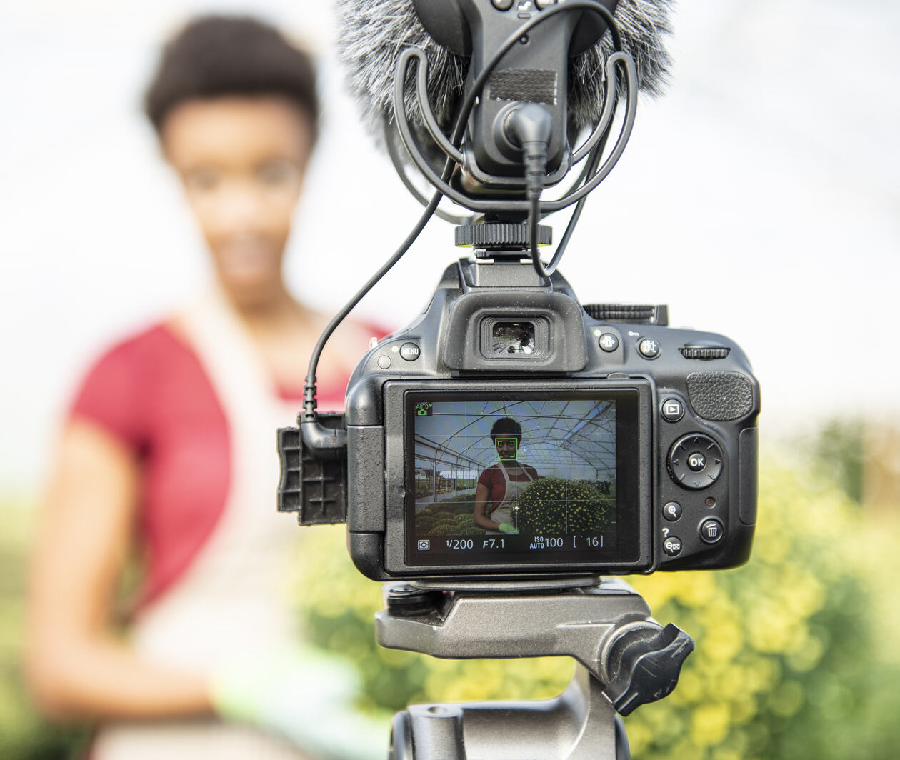 a young woman vlogging in a greenhouse