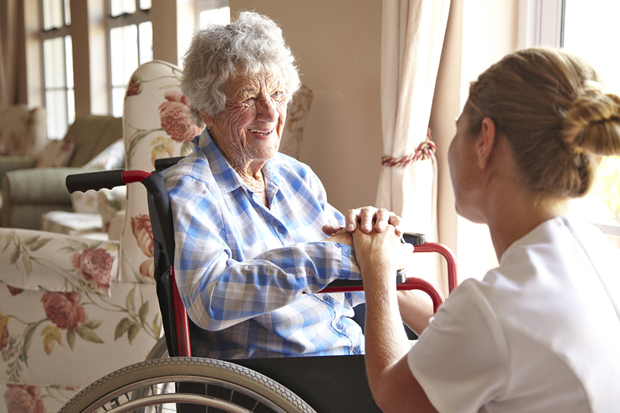 Elderly woman talking to a nurse in a retirement home