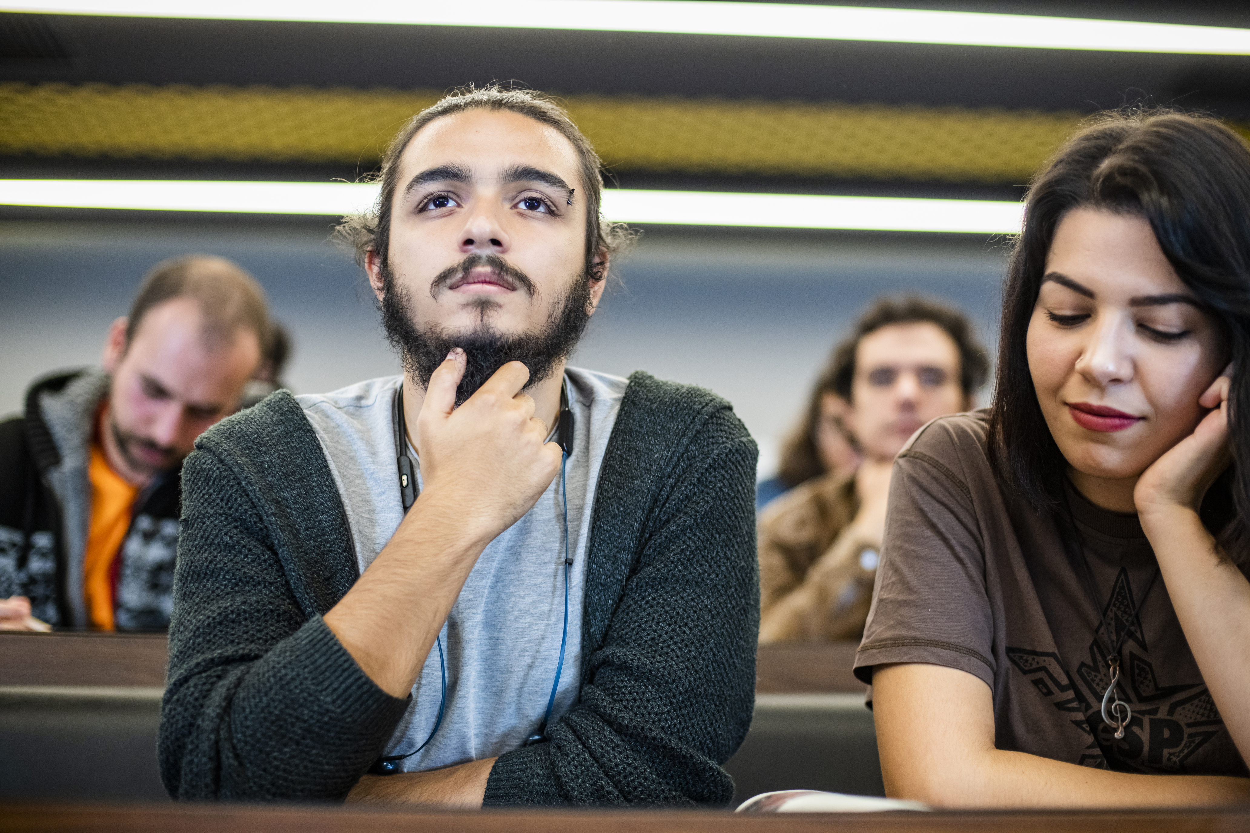 Close up of two university students in a lecture hall watching a lecture.