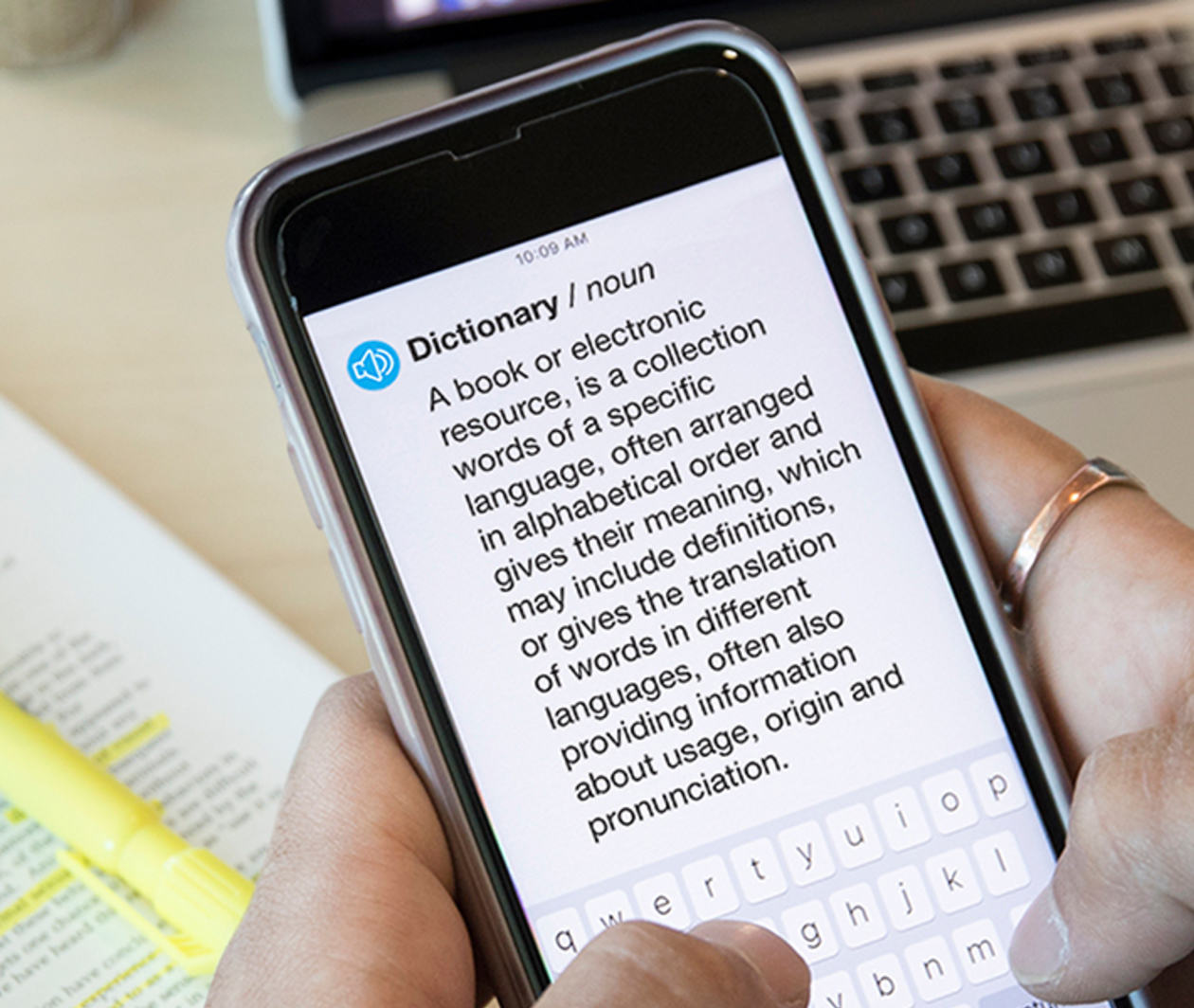 Man holding phone that shows definition of the word 'dictionary'