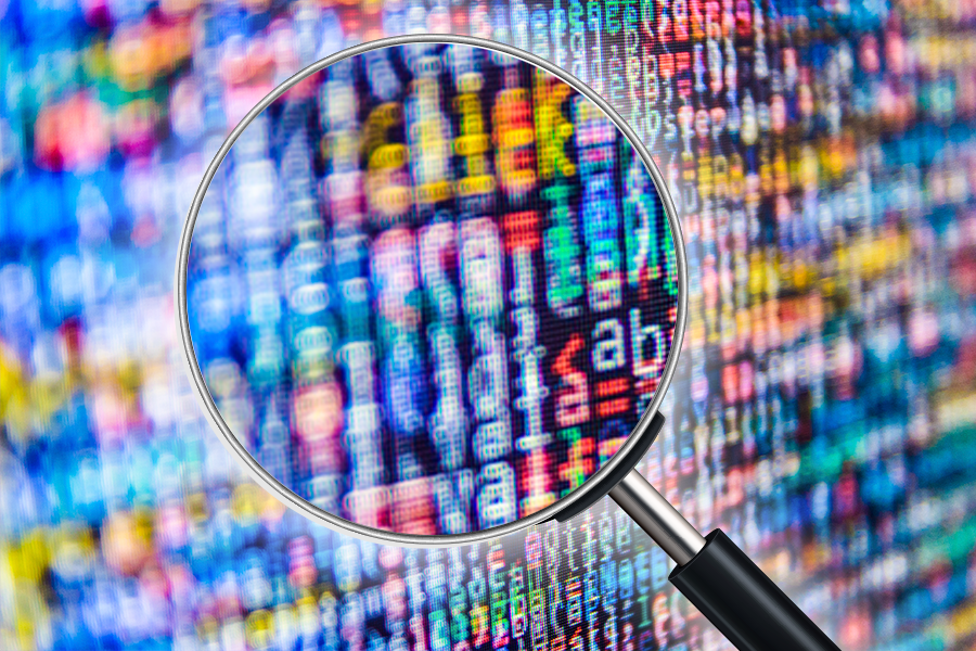 Magnifying glass being used to inspect indistinct computer code or data