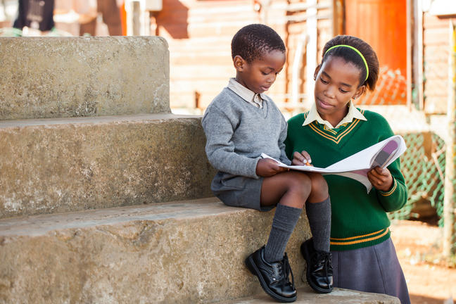 Young lady helps her little brother with homework