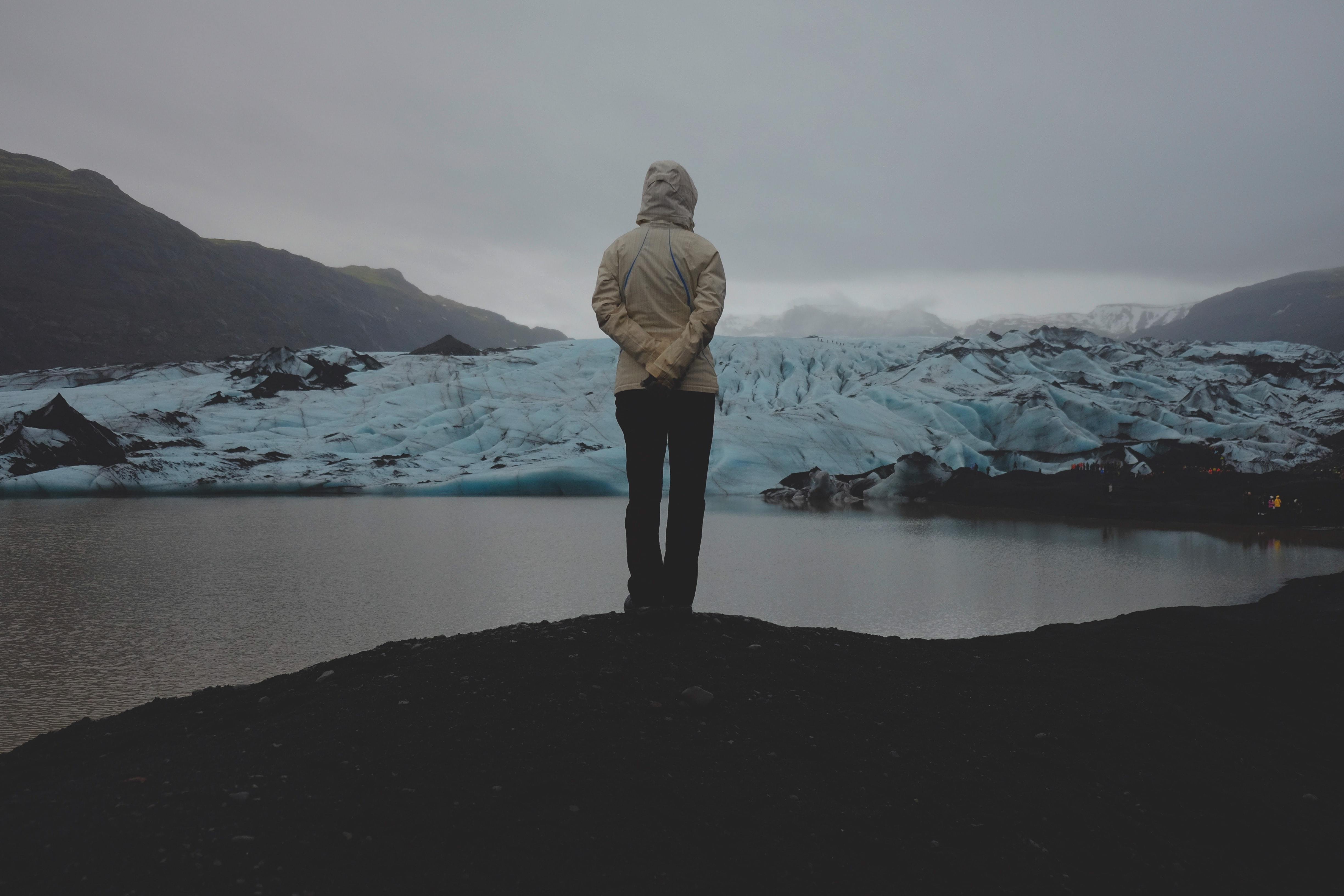 Image of person standing and looking towards a glacier.