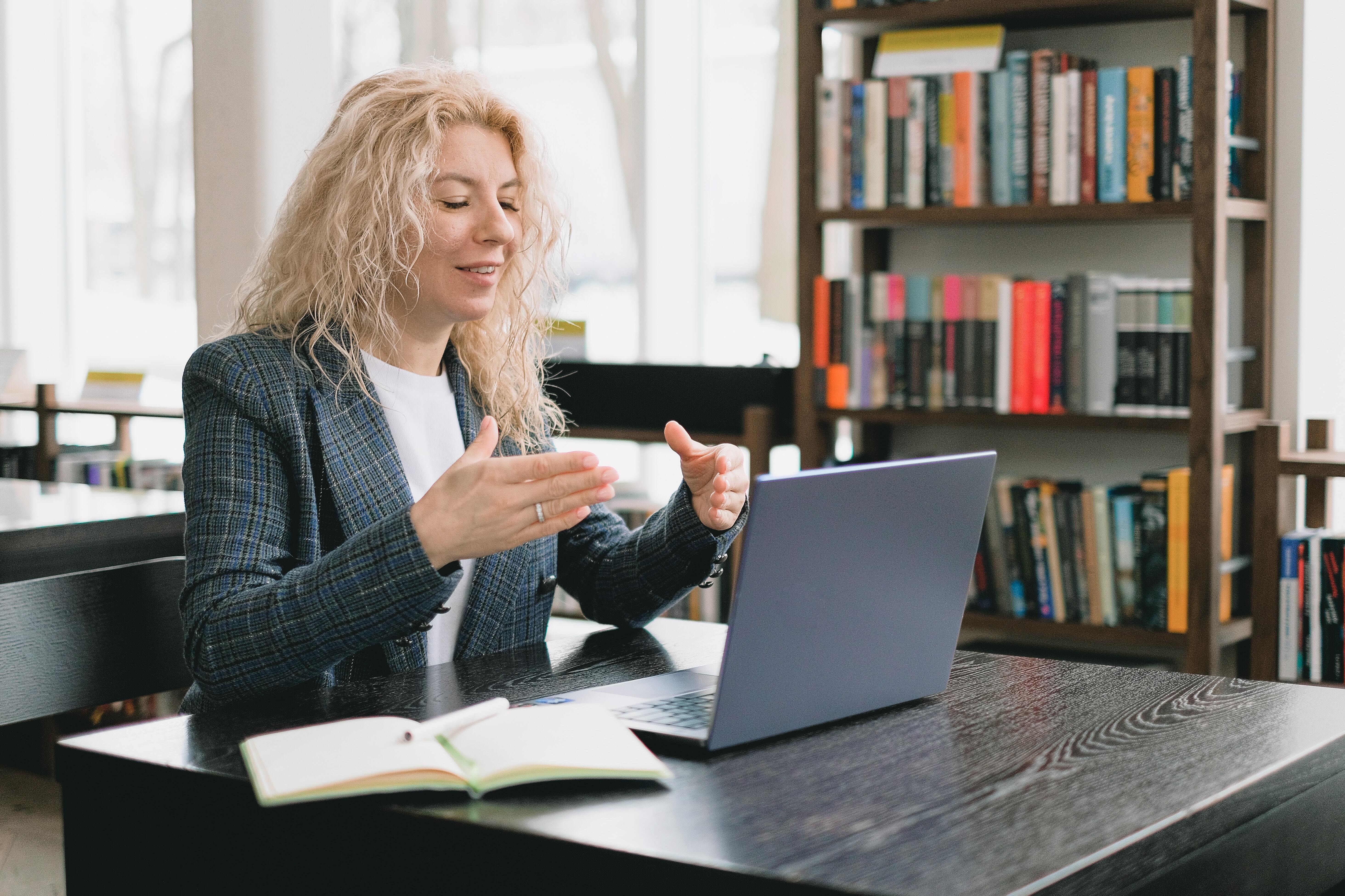 Photo of a women explaining a concept to someone via a laptop