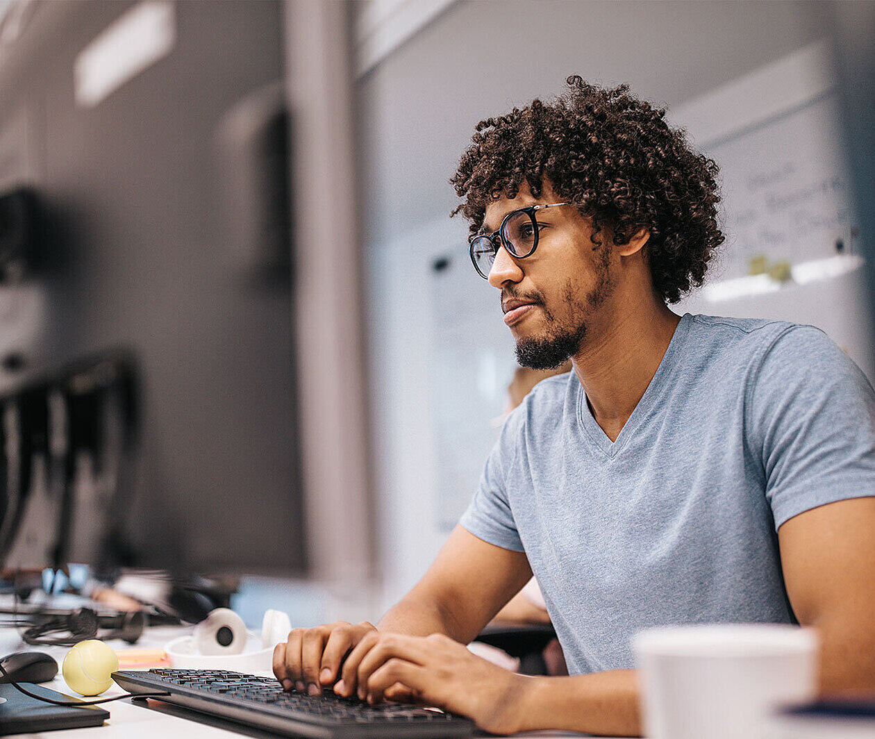 Person using a keyboard at a desktop computer.