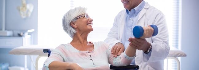 Physiotherapist assisting senior patient with hand exercise as part of an exercise prescription
