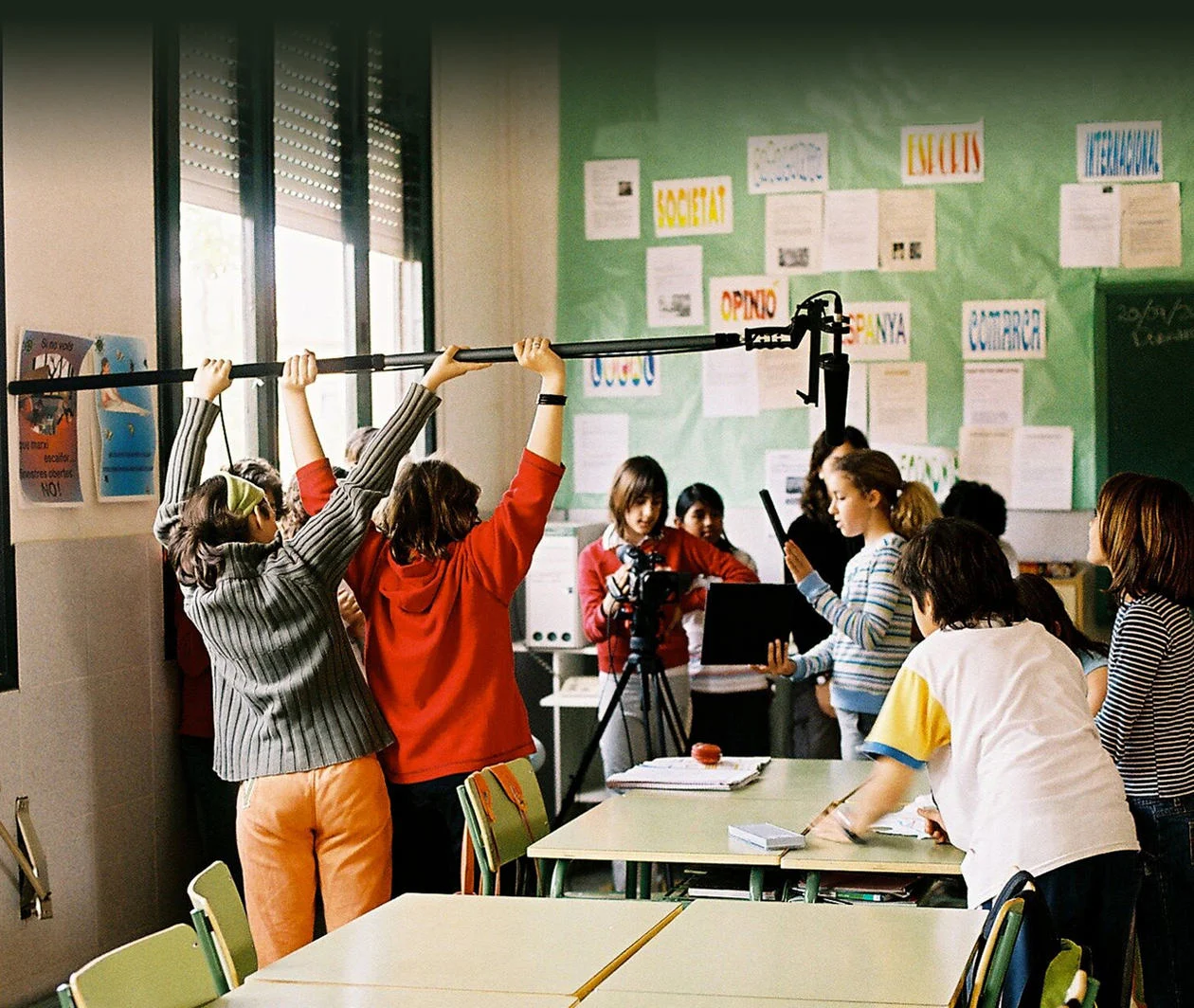 Classroom of children using film equipment to make a film