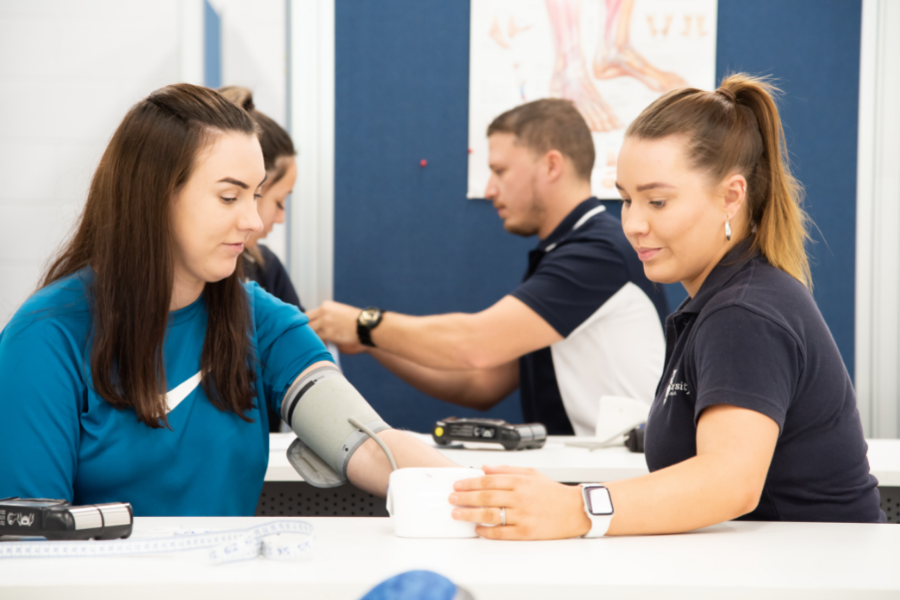 Trainer taking blood pressure of client