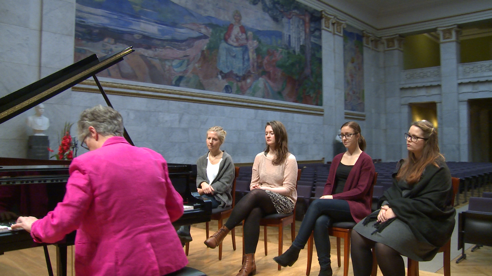 People listening to piano music in an aula.