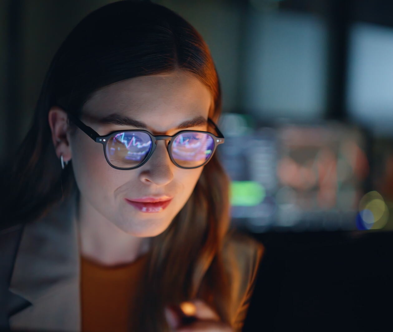 Businesswoman in eyeglasses analyzing financial data on laptop screen reviewing charts focusing on graphs future strategy planning