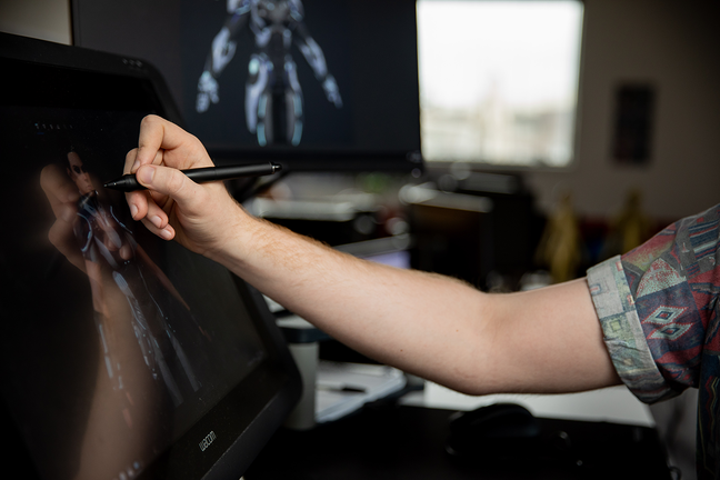 Artist draws games character on a computer screen