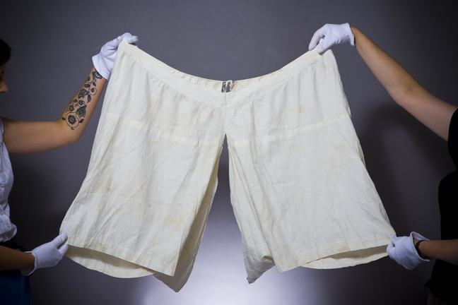 Two people holding up a pair of bloomers