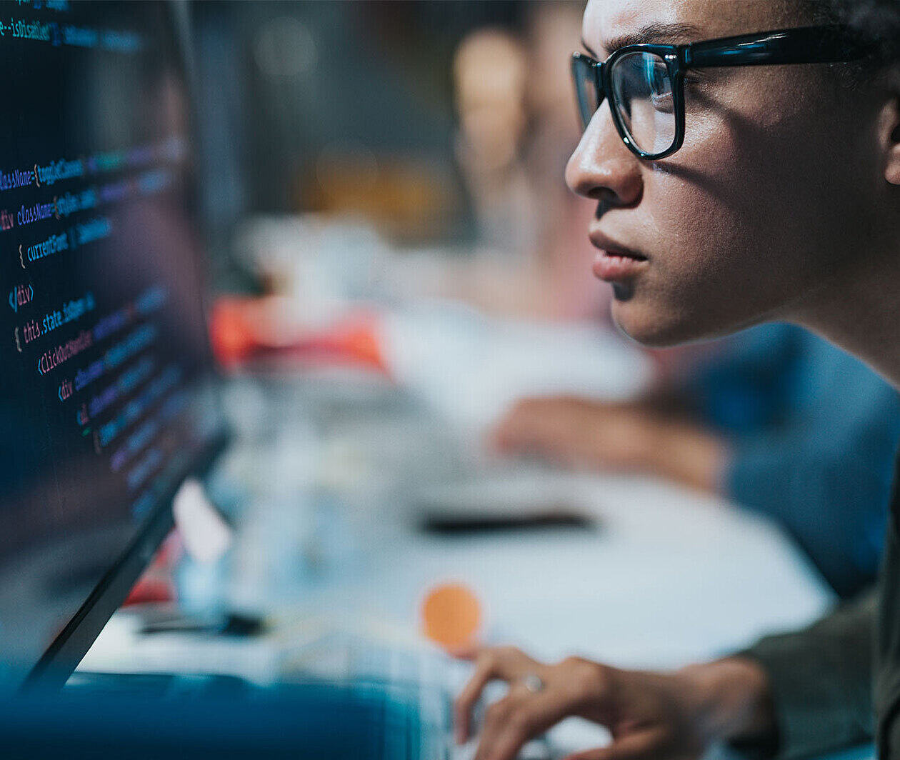 Close up of a man looking at lines of code on a screen.