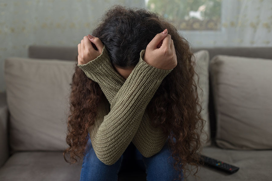 Young girl holds head in distress