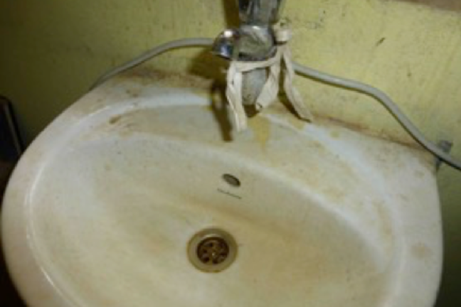An image of a dirty sink and tap is shown.