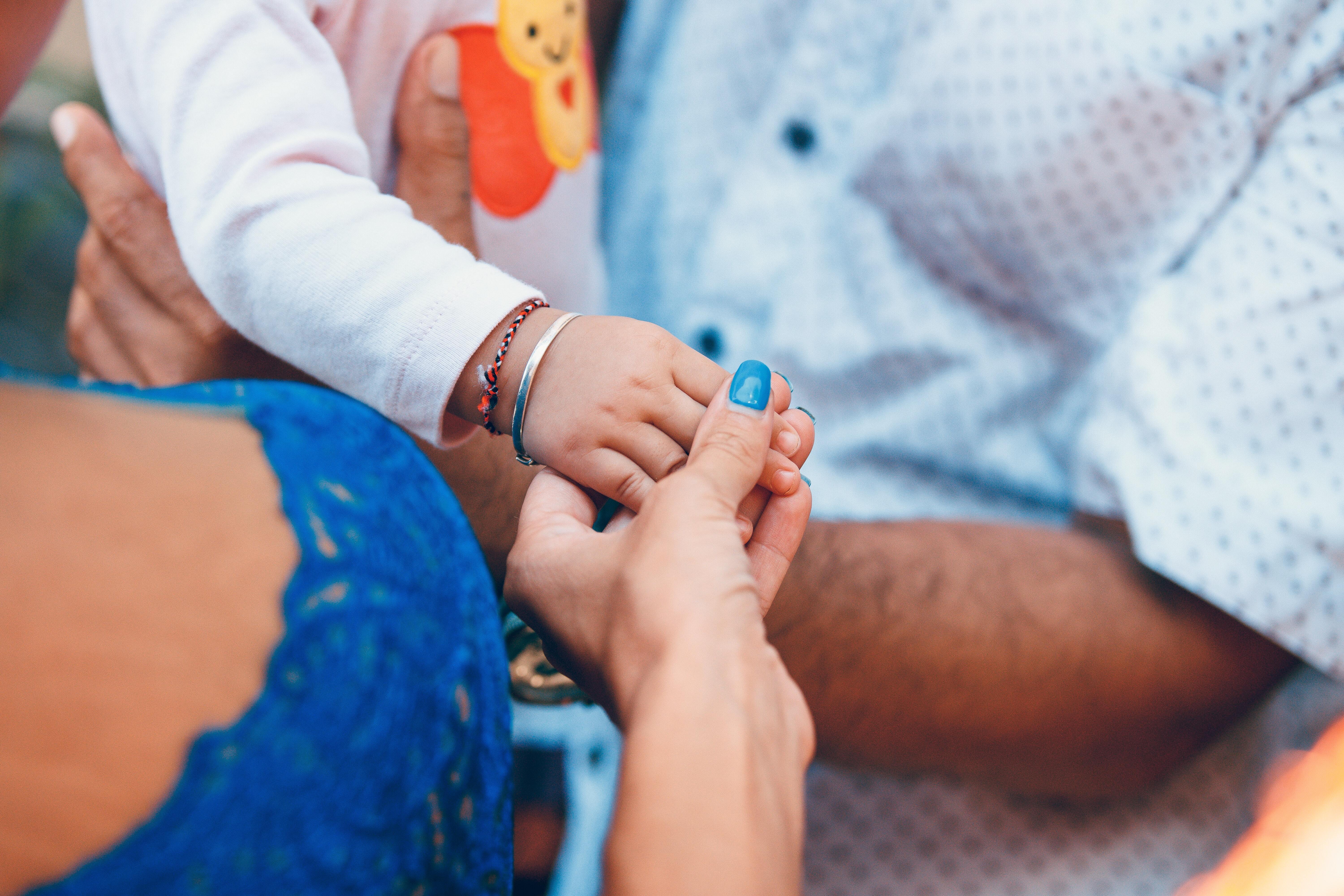 A person holding a child's hand.