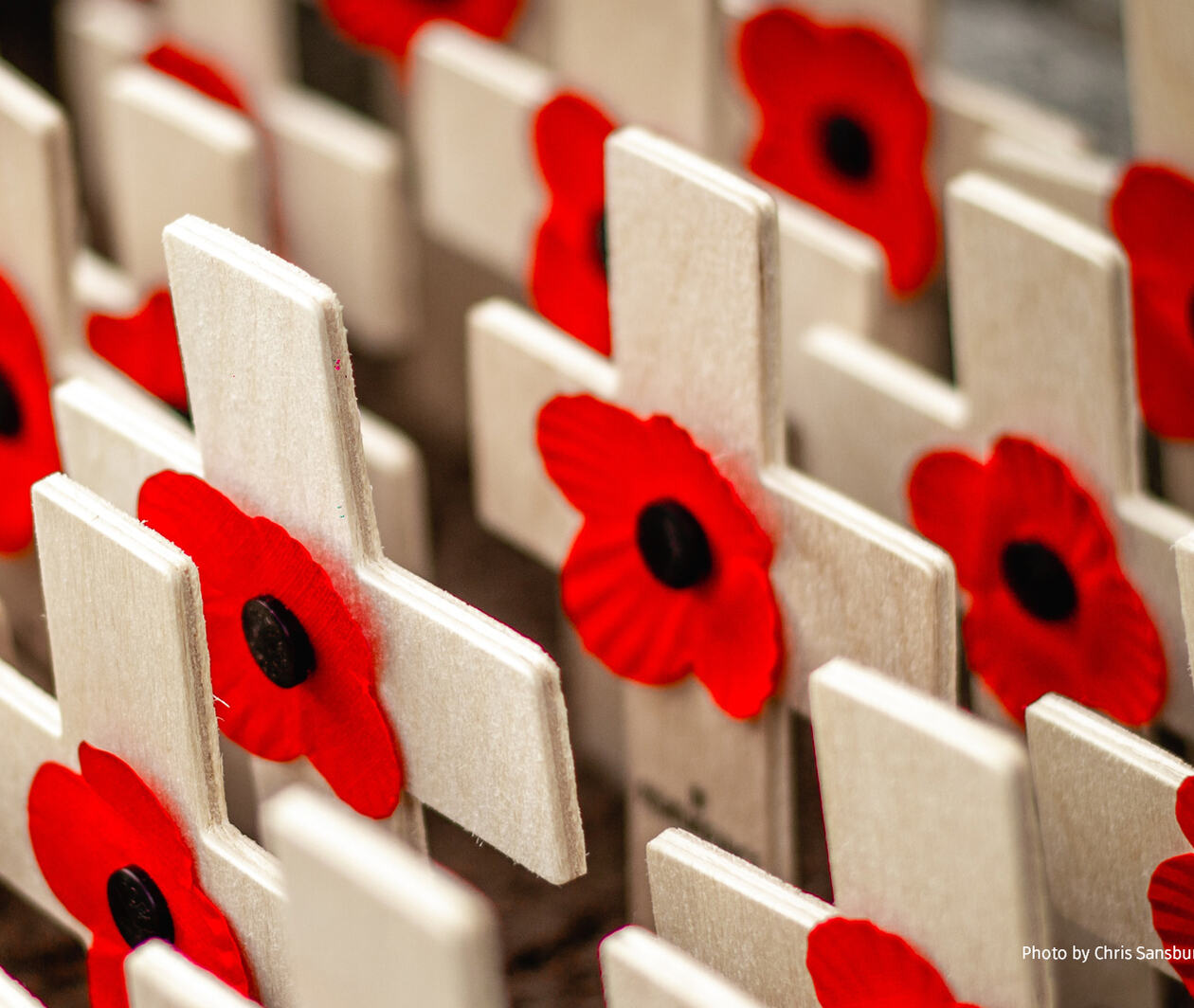 Small timber crosses with red poppies made from fabric and a button