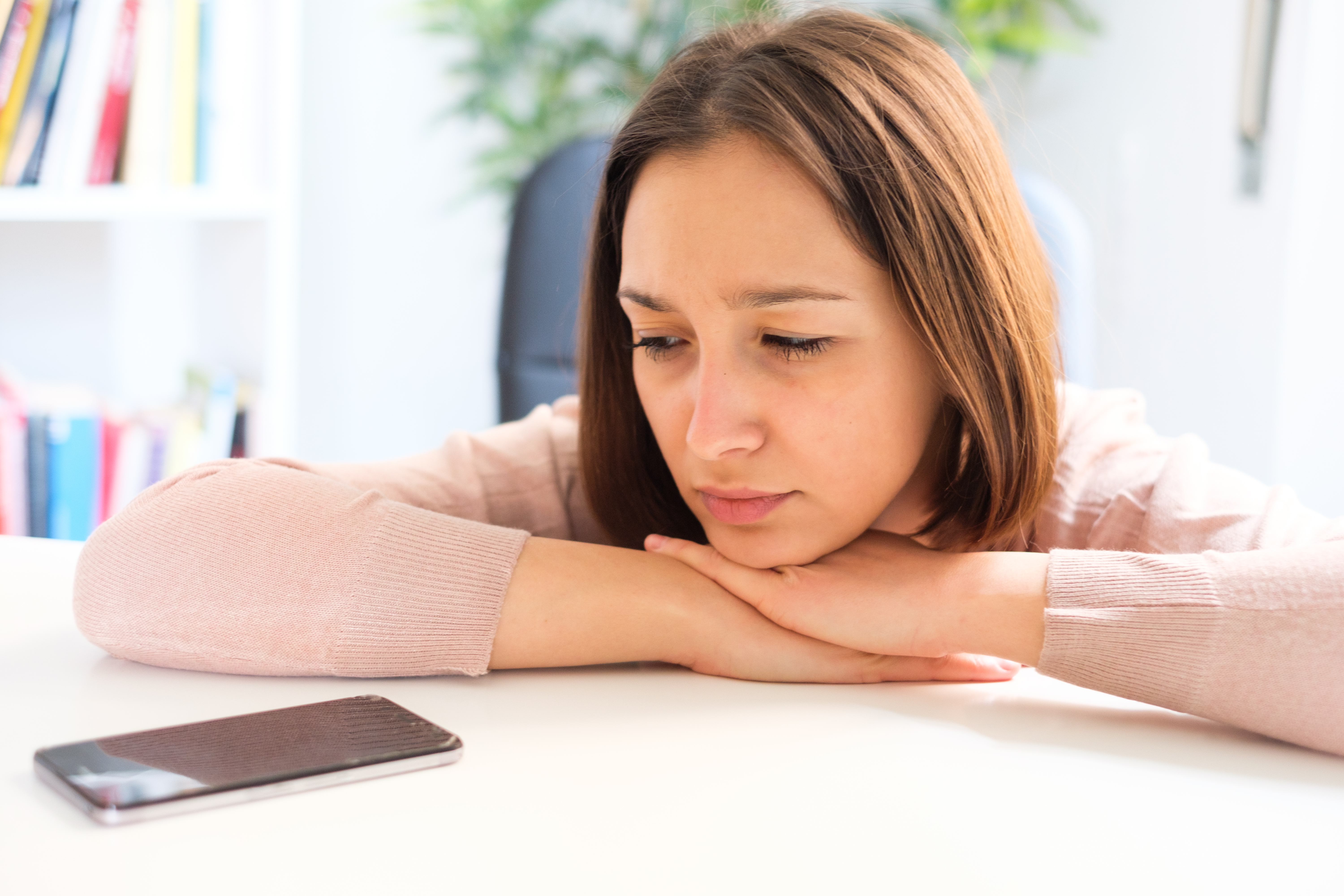 Woman watching phone anxiously