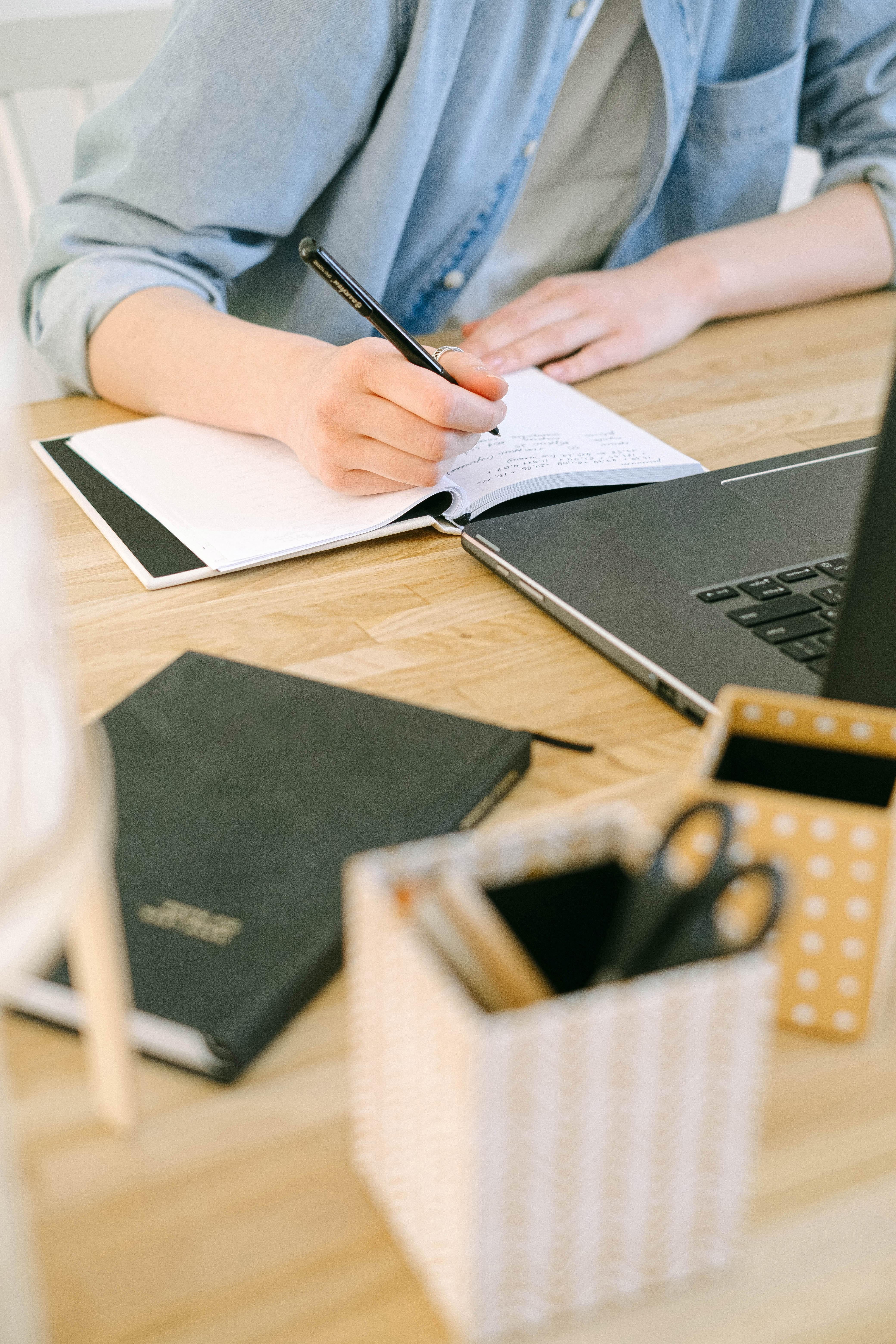 person writing on a notepad