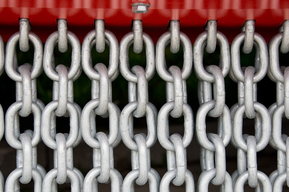 A number of metal chains all aligned in the same direction.