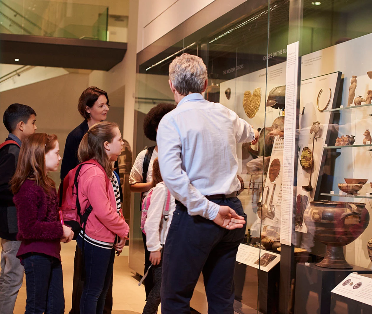 A group of children are shown a display in a museum