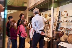 A group of children are shown a display in a museum