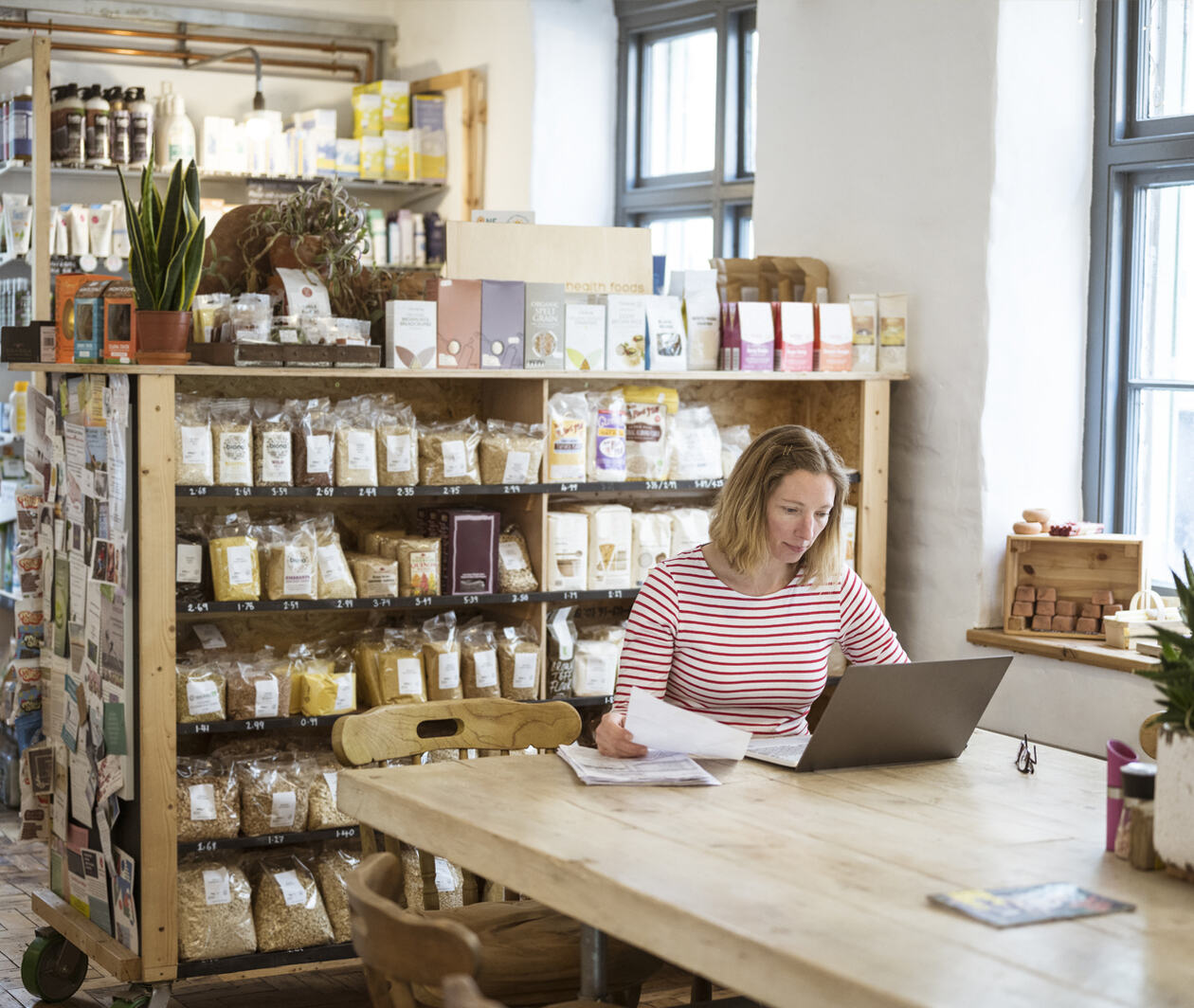 A women sitting working at a laptop at a cafe