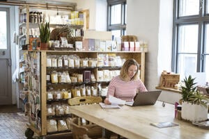 A women sitting working at a laptop at a cafe