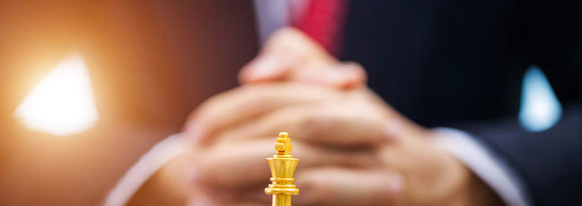 Businessman hand with businessman goal with chess.