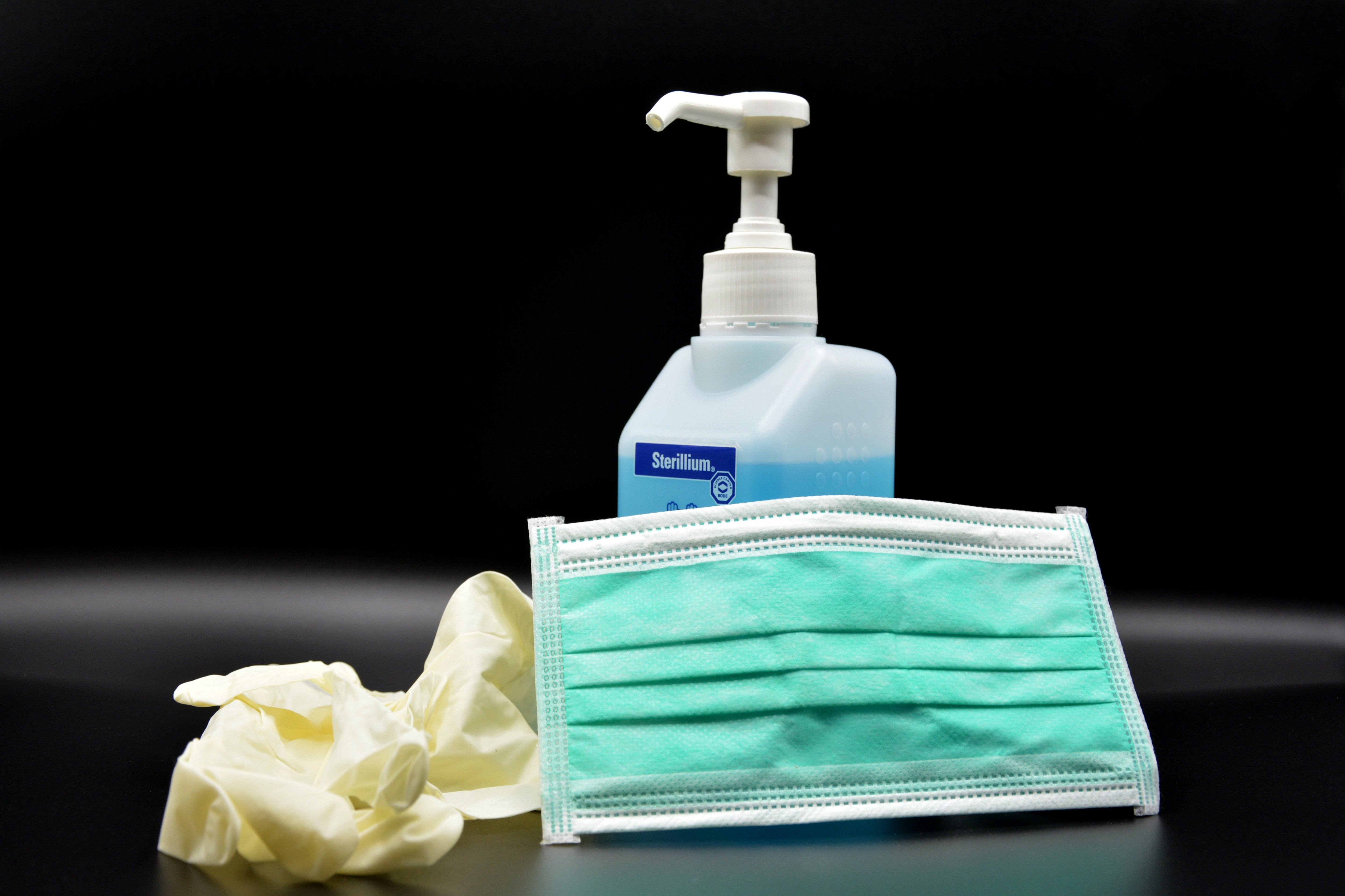 Image of the correct PPE equipment on a table, this included the hand rubbing gel, mask and gloves