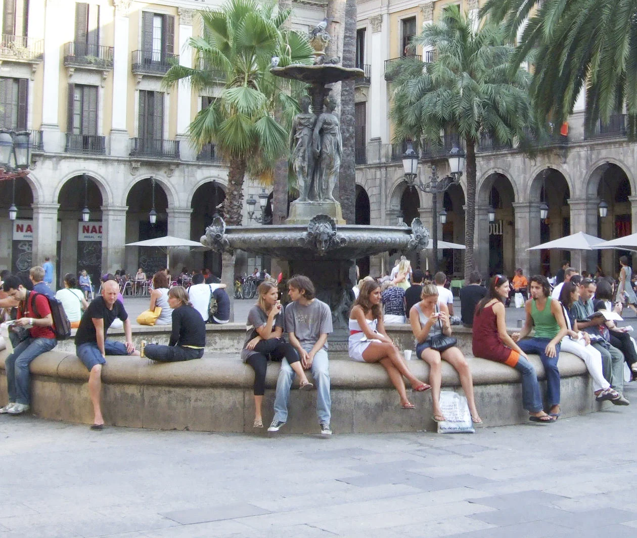 A town square full of people sitting and talking 