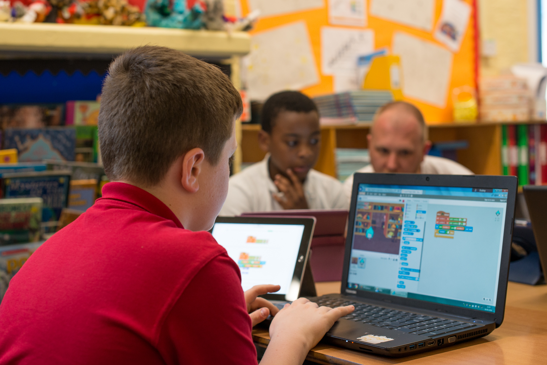 A boy is working on a Scratch programme on a lap top