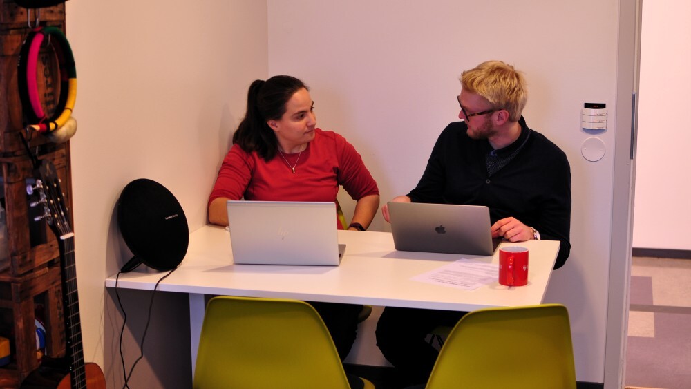 Man and woman talking in office.