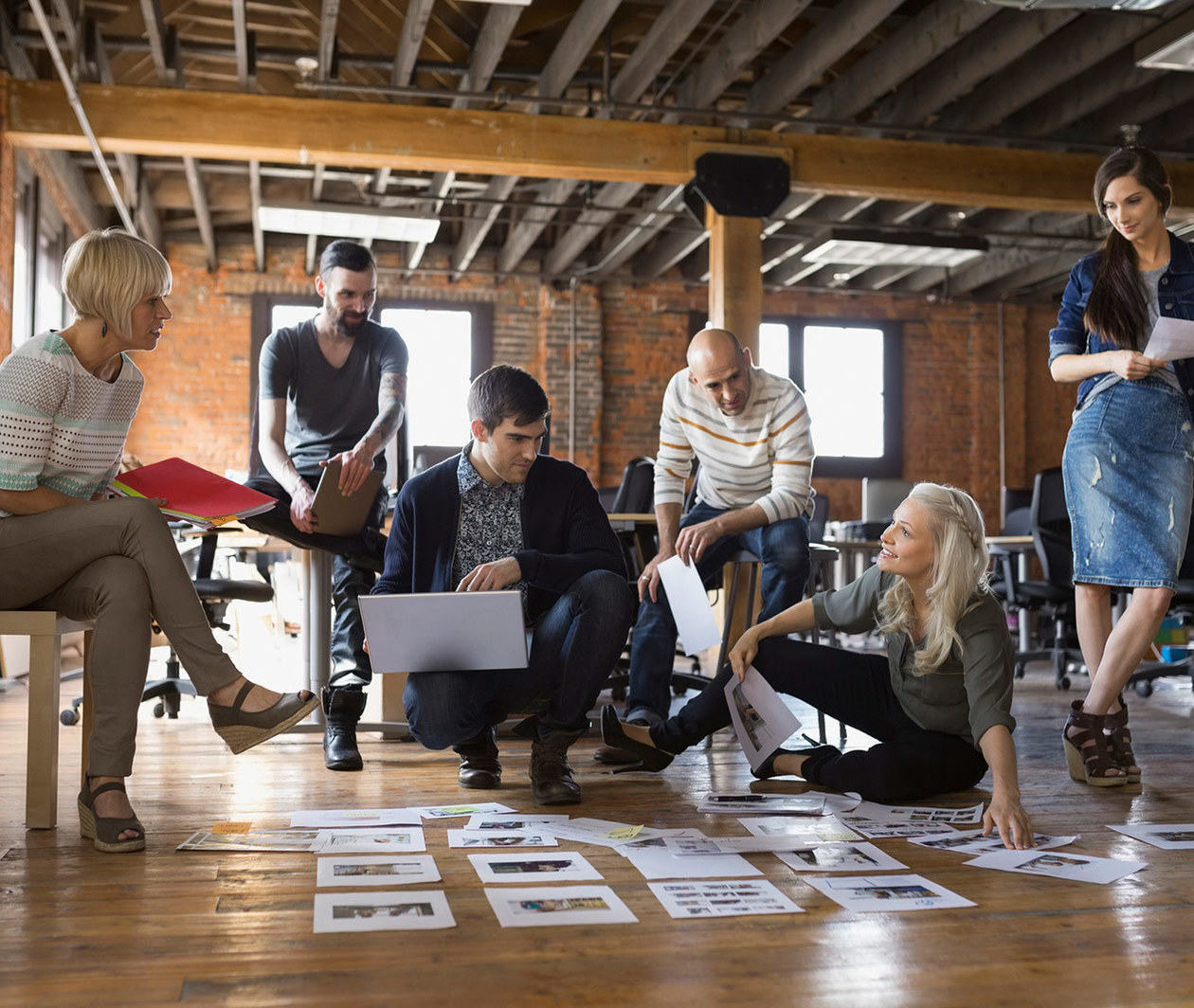 A work team analysing documents spread out on the floor