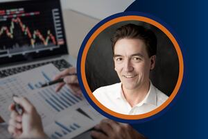A professional headshot of a smiling man in a white shirt, framed in blue and orange. The blurred background shows financial charts, stock data, and hands analyzing reports, representing AI-driven insights and data-driven decision-making