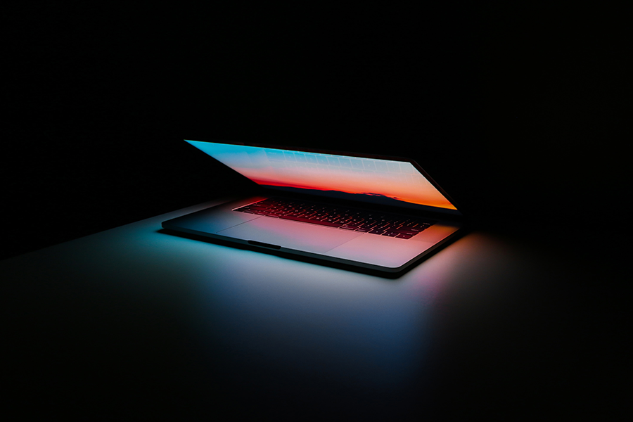 Laptop in dark open slightly and glowing