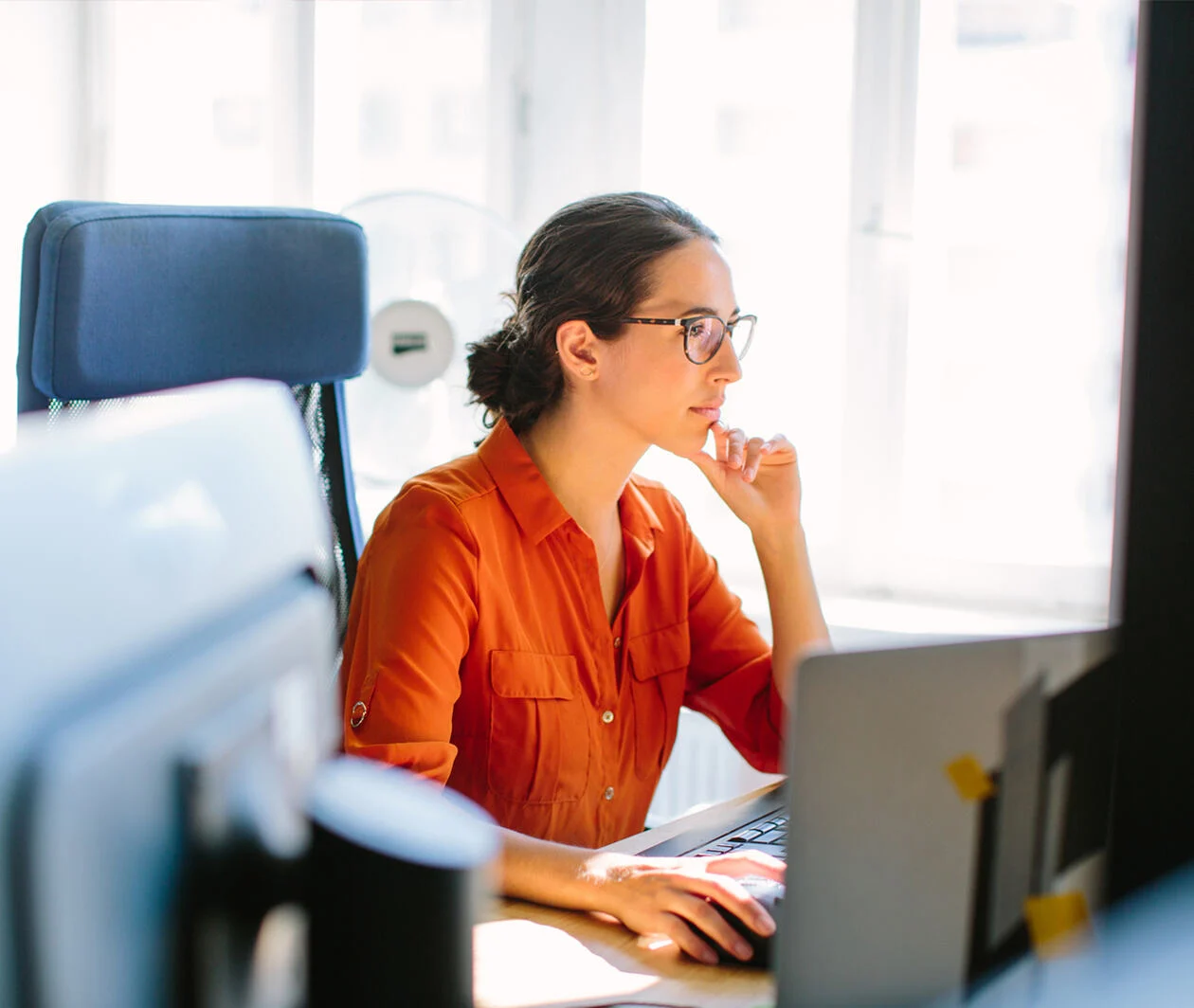 Shot of business woman sitting at her desk and working on desktop computer.