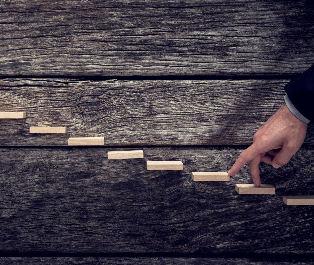 Retro vintage style image of a businessman walking his fingers up wooden steps