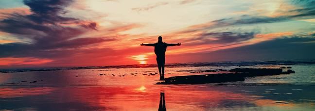 Person embracing an amazing sunset, as if looking into the future