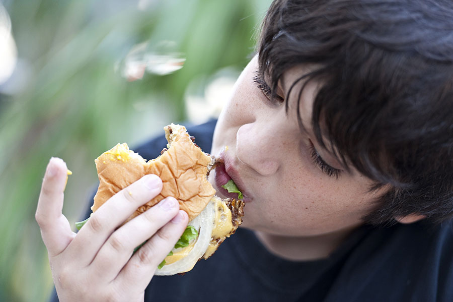 Young boy eating burger