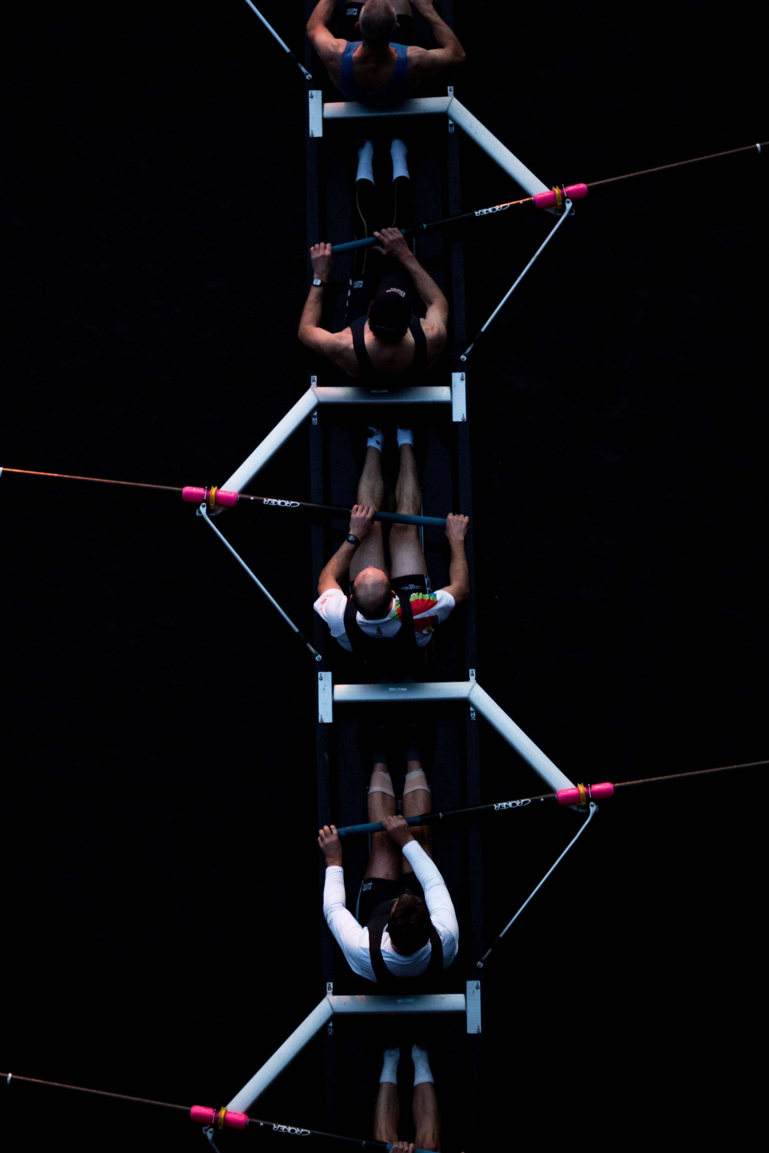 Men rowing on a black background