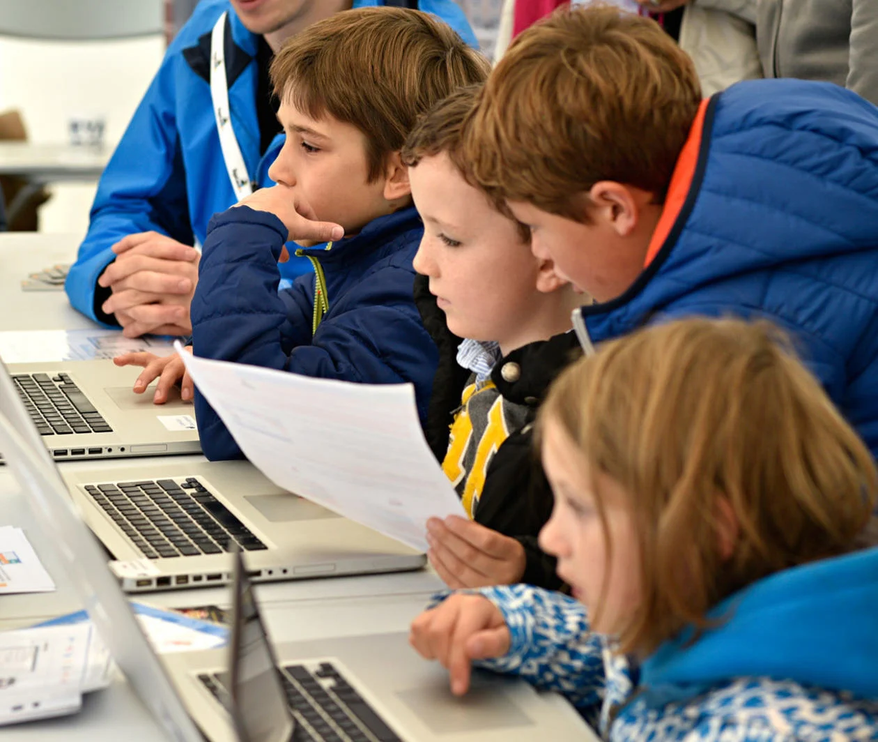 Group of young people on laptops learning how to code 