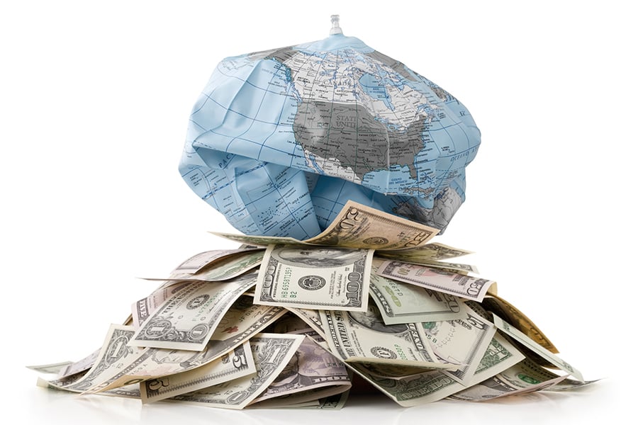 Unsustainable development. Heap of money with globe deflates