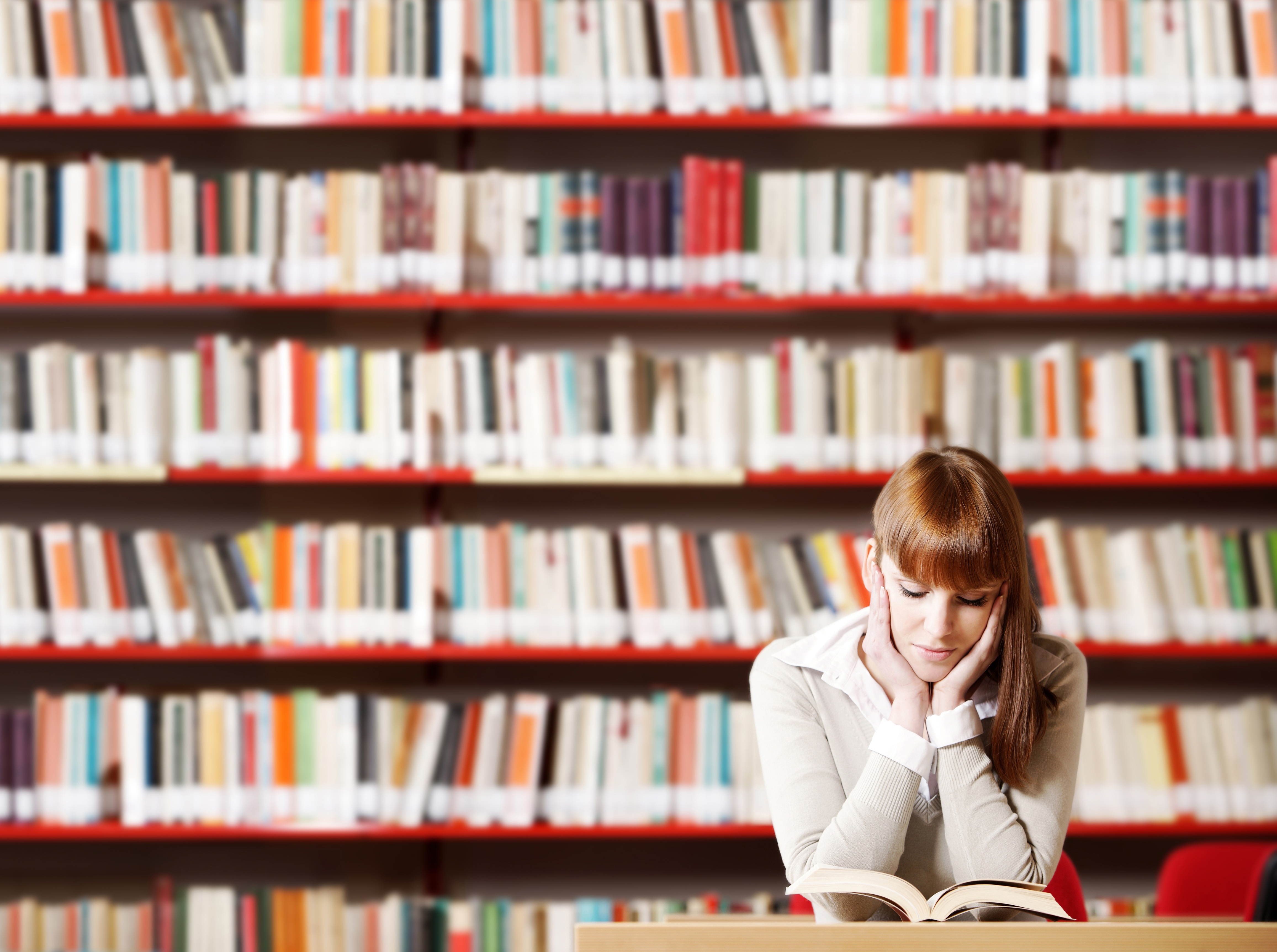 Student reading a book in a library