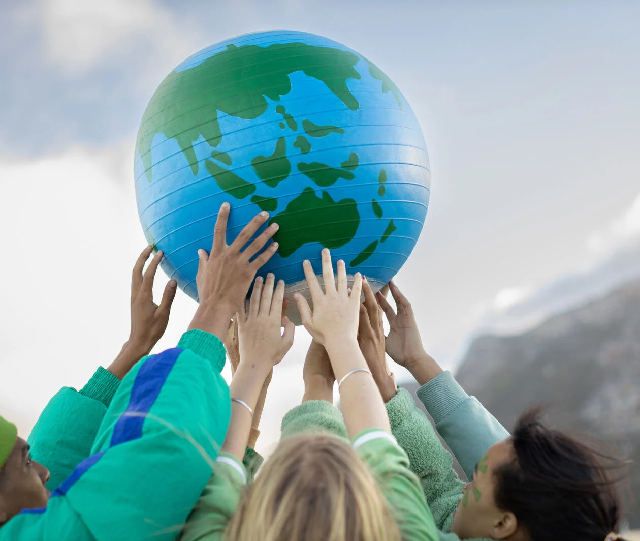 Photograph of a group of young people holding a globe above their heads