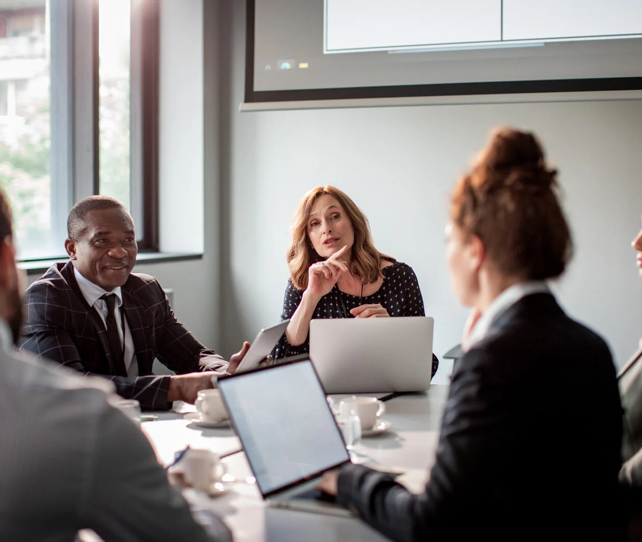 Close up of a group of business people having a meeting in a conference room, the women leader is demonstrating her professional leadership and management skills.