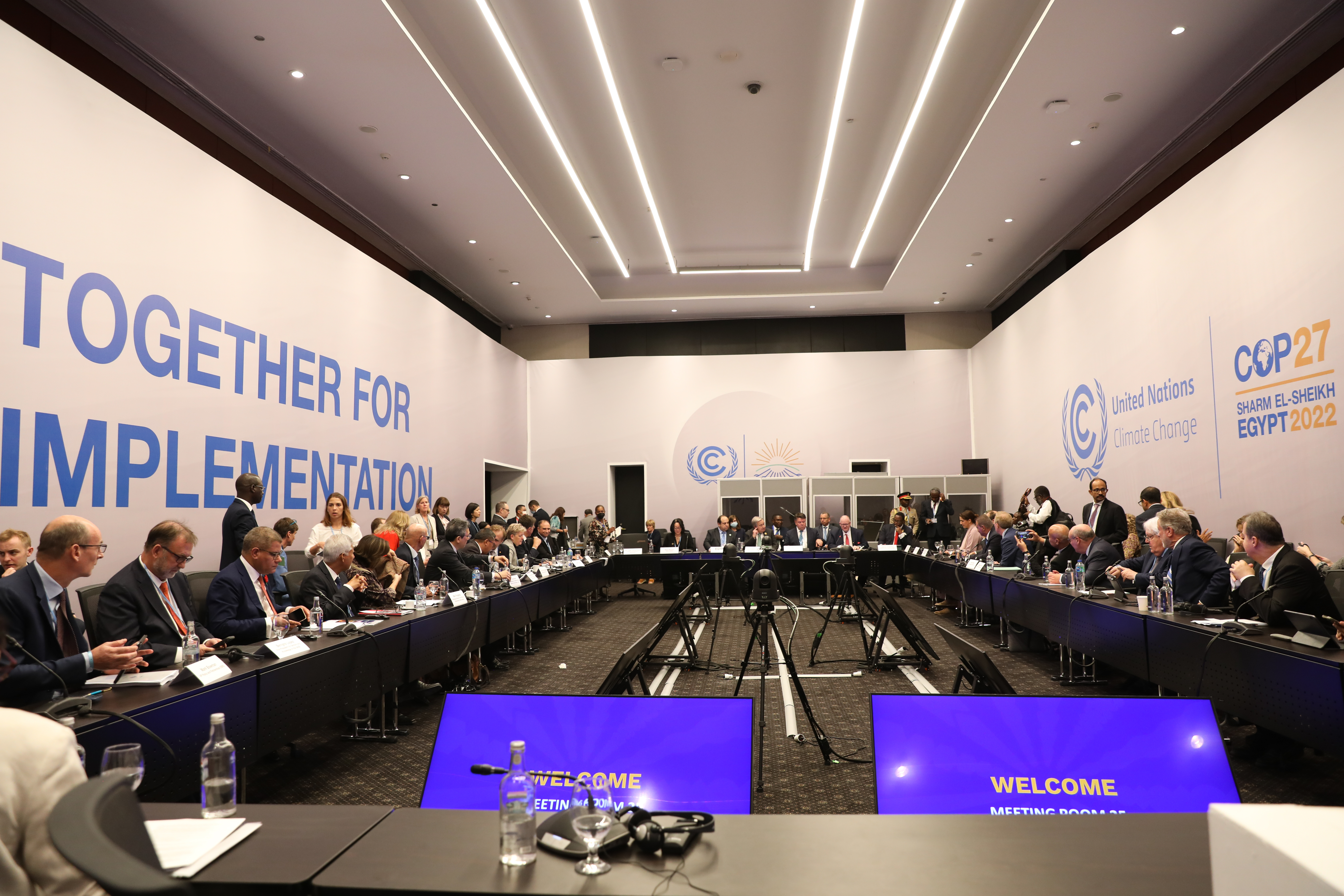 meeting room filled with people and the signs together for implementation on the walls.