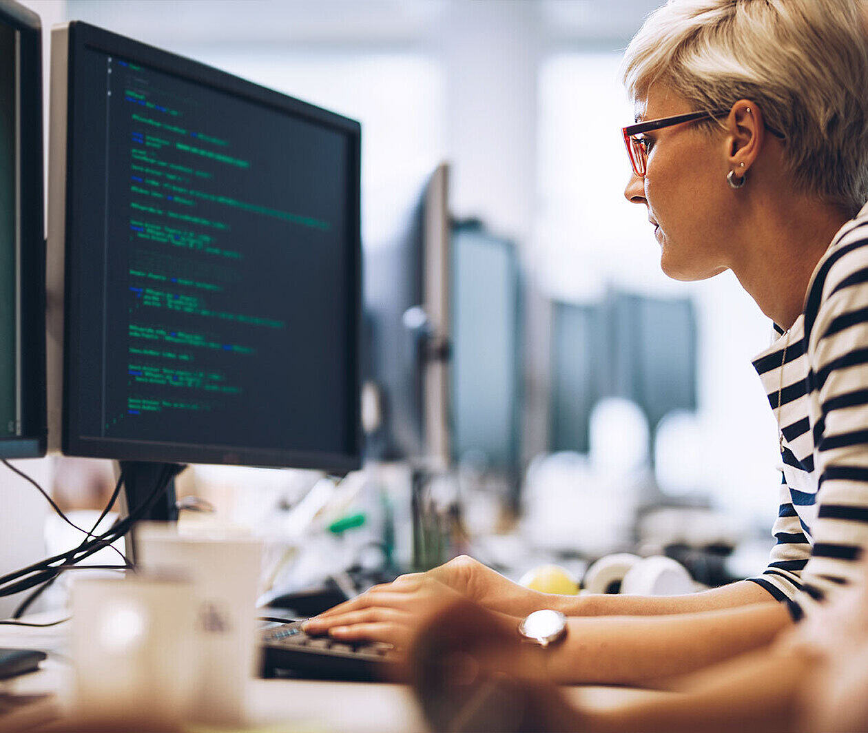  Woman in a stripy top looking at a computer screen.