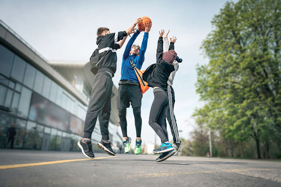 Group of boys jumping to catch basketball